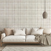 Neutral beige plaid wallpaper in 26 inch repeat styled behind a cream sofa with woven pendant light, neutral pillows, and cozy living room decor