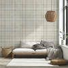 Neutral plaid wallpaper in 52 inch repeat with large scale beige plaid pattern behind white sofa and natural woven decor