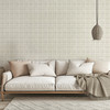 Neutral beige plaid wallpaper in 13 inch repeat styled behind a cream sofa with woven pendant light, neutral pillows, and soft living room decor