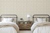 Neutral beige plaid wallpaper in 13 inch repeat styled in a farmhouse bedroom with twin beds, black metal headboards, wood nightstand, and cream bedding