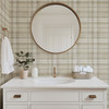 Neutral beige plaid wallpaper in 26 inch repeat styled in a bathroom with white vanity, round mirror, brass accents, and woven basket decor