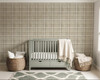 Neutral beige plaid wallpaper in 26 inch repeat styled in a sage green nursery with crib, woven baskets, cream blanket, and soft natural decor