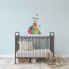 Small woodland deer and birds nursery wall decal displayed above a black metal crib on a pale blue wall