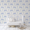 Light blue bow trellis wallpaper in a neutral nursery with white crib