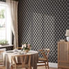 Dark floral wallpaper in black with a repeating bloom motif styled in a dining room
