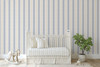 Blue striped wallpaper with warm gold accents styled in a nursery with a soft modern look
