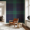 Green tartan wallpaper shown in a cozy bedroom accent wall
