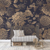 Midnight Botanica navy and gold floral nursery wallpaper with a black metal crib and wooden rocking horse, shown in the 104-inch repeat