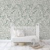 Neutral nursery featuring white crib and Rosemary Botanical Wallpaper with vintage herbarium fern pattern.