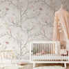 Magnolia Chinoiserie Wallpaper styled in a baby girl nursery with white crib, peach canopy, soft rug, and delicate floral branch pattern