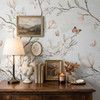 Magnolia Chinoiserie Wallpaper styled with rustic wood dresser, table lamp, framed art, butterflies, and soft floral botanical wall pattern