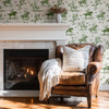 Weathered Green Cowboy Wallpaper styled in a cozy fireplace room with leather chair, throw blanket, woven pillow, and vintage cowboy horse illustrations