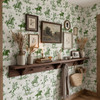 Weathered Green Cowboy Wallpaper styled in an entryway with floating wood shelf, framed art, woven basket, dried flowers, and vintage rodeo decor