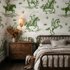 Weathered Green Cowboy Wallpaper styled in a moody bedroom with wood nightstand, wall sconce, layered bedding, boots, and vintage cowboy horse pattern