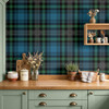 Blue Green Tartan Plaid wallpaper styled in a farmhouse kitchen with green cabinets, wood counter, kitchen jars, plants, dried flowers, and classic plaid wall decor