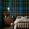 Blue Green Tartan Plaid wallpaper styled in a moody bedroom with wood nightstand, wall sconce, layered bedding, boots, and rustic tartan wall pattern