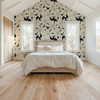 Black and cream abstract floral wallpaper on a vaulted bedroom accent wall