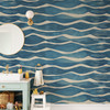 Coastal blue wave wallpaper behind contemporary furniture on a statement wall