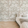 Chinoiserie wallpaper with soft botanical branches and birds styled in a neutral nursery