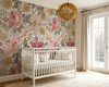 Natalia vintage pink floral wallpaper in a bright nursery with a white crib and woven pendant light, shown in the 78-inch repeat