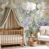 Sarah sage green floral wallpaper with oversized lavender, cream and yellow botanical flowers behind a natural wood crib
