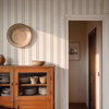 Sage green striped wallpaper in bedroom creating a timeless cottage inspired retreat