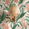 Botanical green floral wallpaper with coral flowers and brass sconce