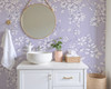 Round mirror bathroom decorated with Eleanor Lavender Roses lavender botanical wallpaper.