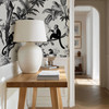 Black and ivory monkey wallpaper decorating a traditional hallway with tropical botanical design