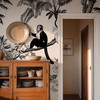 Vintage tropical wallpaper behind sage green bedside cabinet with monkey and palm tree pattern