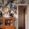 Vintage tropical wallpaper in entryway with monkeys, palm trees and warm wood furniture