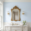 Victorian style bathroom with blue gingham wallpaper and ornate gold mirror