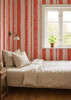 Feminine pink stripe wallpaper in a bedroom with vintage furniture