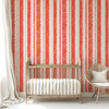 Coral pink stripe wallpaper with delicate white lace detail in a nursery