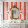 Pink lace stripe wallpaper in a vintage bathroom with white vanity and gold mirror