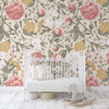 Girls nursery featuring vintage floral wallpaper with white crib, pink roses, botanical leaves, and yellow flowers