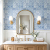 Blue Moroccan bathroom wallpaper behind wood vanity and arched mirror, 13-inch repeat