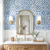 Blue Moroccan bathroom wallpaper behind wood vanity and arched mirror, 26-inch repeat