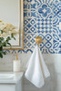Blue Moroccan tile wallpaper bathroom close-up with brass towel hook and white tile, 26-inch repeat