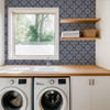 Blue tile wallpaper in 26-inch pattern scale in a laundry room with window, sink and wood shelves