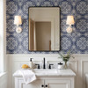 Blue fleur-de-lis bathroom wallpaper in 26-inch repeat with white wall paneling, black mirror, and marble vanity