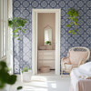 Navy blue tile wallpaper in 26-inch repeat in a bright French farmhouse bedroom with arched doorway and vintage chair