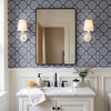Blue fleur-de-lis bathroom wallpaper in 13-inch repeat with white wall paneling, black mirror, and marble vanity