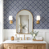 French country blue tile wallpaper in 13-inch repeat in a bathroom with light wood vanity and rectangular mirror