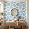 Linnea Blue Watercolor Floral Wallpaper in a bathroom with smaller floral repeat, wood vanity, and round mirror
