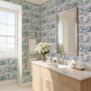 Marina blue Atlantic wave wallpaper in 26 inch repeat styled in a modern bathroom with wood vanity, silver mirror, white flowers, and marble countertop