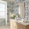 Marina blue Atlantic wave wallpaper in 52 inch repeat styled in a modern bathroom with wood vanity, silver mirror, white flowers, and marble countertop
