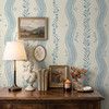 Elsie Heritage Blue floral stripe wallpaper in 52 inch repeat shown close up behind a vintage dresser with lamp, framed art, and English cottage decor