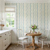 Elsie Heritage Blue floral stripe wallpaper in 26 inch repeat styled in a bright kitchen dining nook with cream cabinetry, round wood table, white chairs, and cottage decor