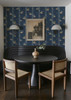 Fruit Compote Navy Blue retro dining room wallpaper in 52 inch repeat styled in a breakfast nook with black round table, wall sconces, and vintage framed art